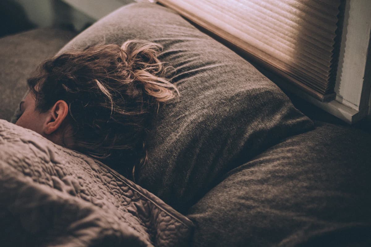 Persoon ligt rustig in bed met aandacht op ademhaling voor het slapen