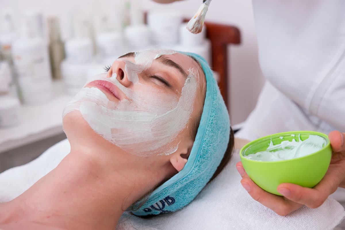 Huidtherapeut voert een microneedling-behandeling uit op het voorhoofd van een vrouw met een dermapen