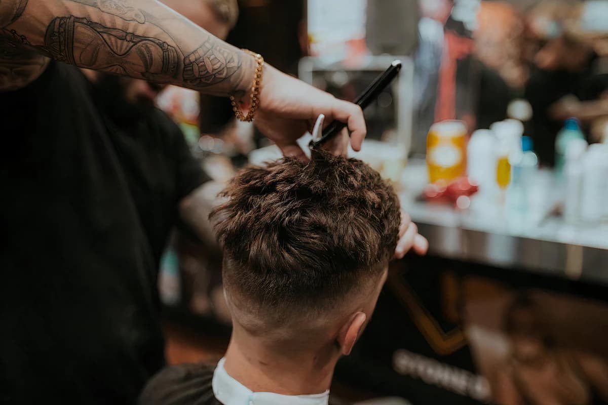 Man krijgt een nette fade en baardtrimming bij een barbier in een klassiek interieur
