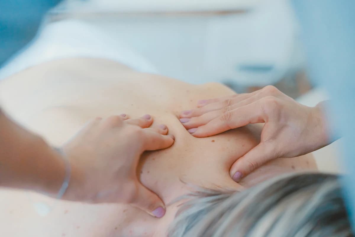 Zwangere vrouw ligt op haar zij tijdens een ontspannende zwangerschapsmassage